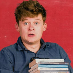 A picture of Tom Nicholas holding some books.